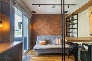 Un espacio moderno para vivir con un sofá, una mesa de comedor de madera y una pared de ladrillo.