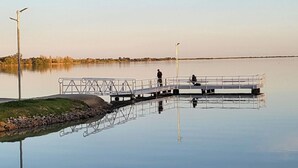 Ein ruhiger See mit einem Steg, der sich ins Wasser erstreckt.