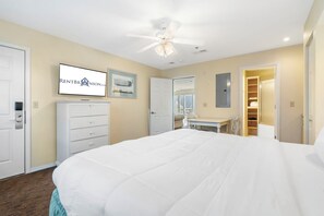 A bedroom with a bed, a dresser, a desk, and a closet.