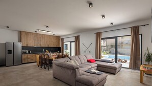A modern living room with a sectional sofa, a dining area, and a kitchen. - Villa Claudio With Private Pool (Vodice)