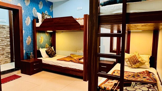 A room with bunk beds, a blue leaf-patterned wall, and a tiled floor. - Deena Residency (Varanasi)