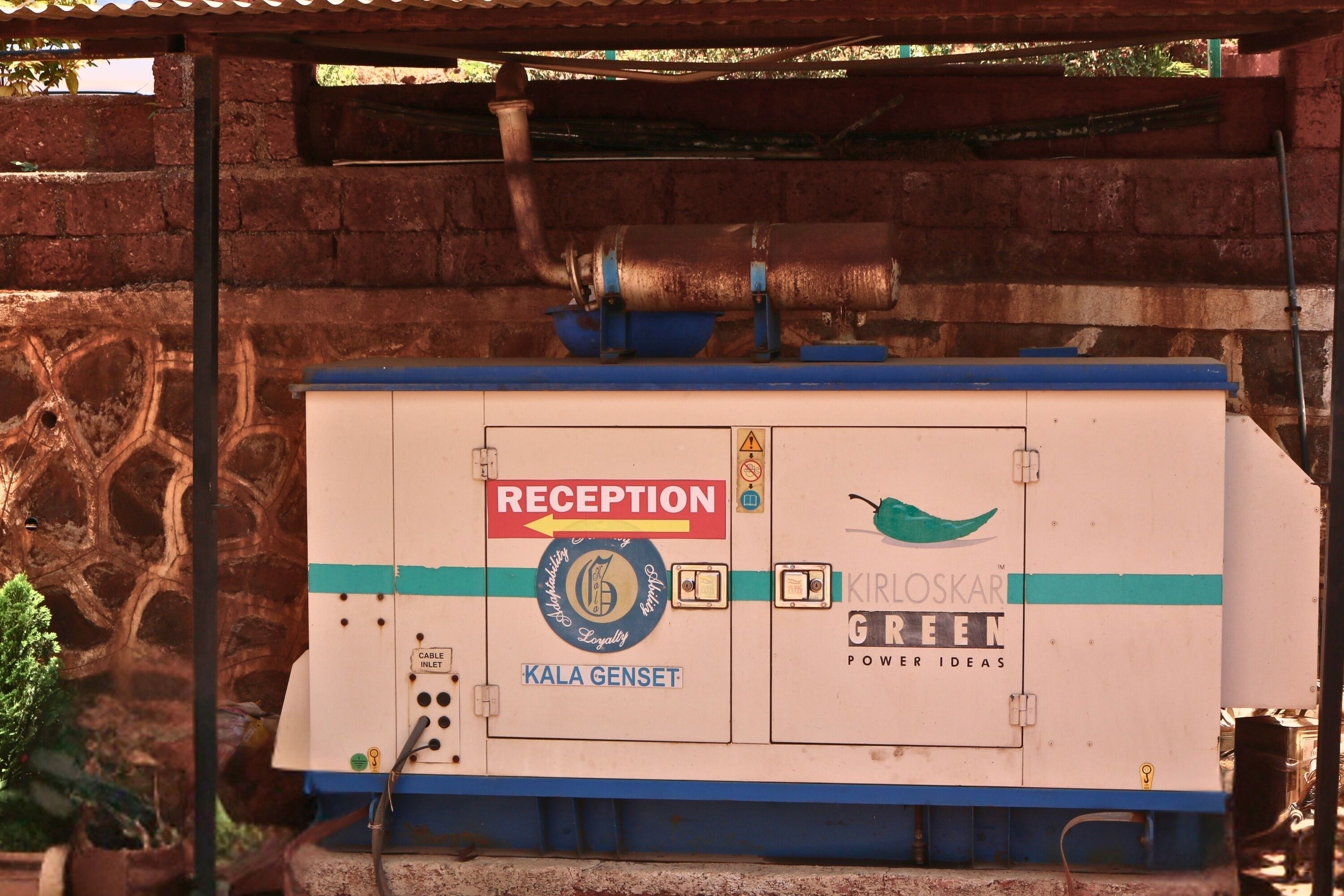 Un espace d’accueil avec une enseigne indiquant « RÉCEPTION », un logo pour « KALA GENSET » et une prise de courant.