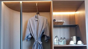 Une salle de bain moderne avec un peignoir suspendu, un lavabo et une étagère contenant des articles de toilette.