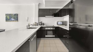 Una cocina moderna con una isla grande, electrodomésticos de acero inoxidable y un diseño minimalista.