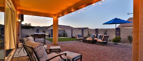 An outdoor patio with brick flooring, a barbecue grill, and outdoor furniture.