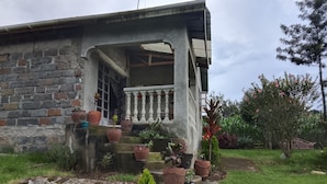 Uma casa com varanda, degraus e vasos de plantas.
