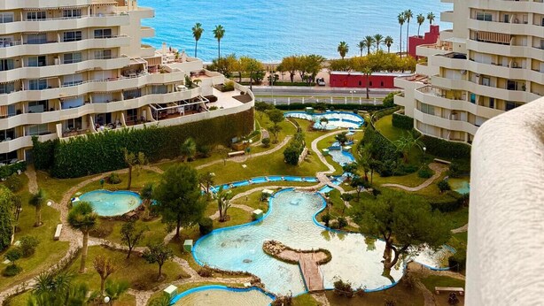 A resort with multiple swimming pools, a view of the sea, and several buildings with balconies. - Charming Apartment with Sea and Garden View (Benalmádena)