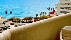 A balcony with a view of the sea and a building with multiple floors. - Charming Apartment with Sea and Garden View (Benalmádena)