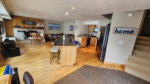 Una cocina amplia con piso de madera, una isla central y un comedor con sillas.