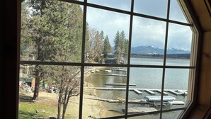 Una habitación con un amplio ventanal de forma octogonal con vistas a un lago, muelles y una zona boscosa.