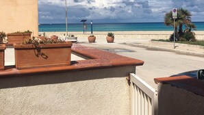 A coastal view with a beach, potted plants, a street lamp, and a no parking sign. - ON THE WATERFRONT UNIQUE LOCATION!!!! (San Vito Lo Capo)