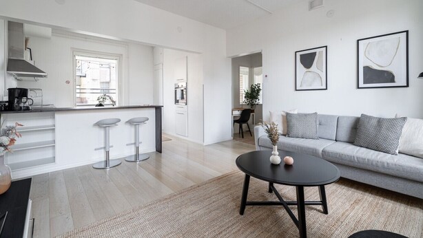 Un espacio habitable moderno con cocina, comedor y un conjunto de sofás.