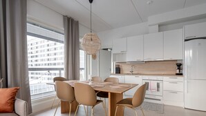 A modern kitchen with white cabinets, a wooden countertop, and a built-in oven.