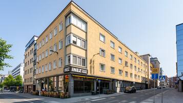 A corner building with multiple floors, featuring a ground-floor bar named "INEZ TAPAS BAR".