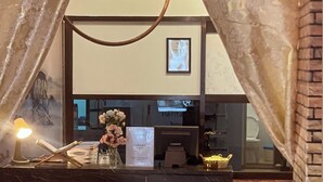A reception desk with a marble top, a framed map on the wall, and a vase of flowers. - Heritage House 123 (George Town)