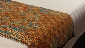 A bed with a patterned blanket and two pillows. - Heritage House 123 (George Town)