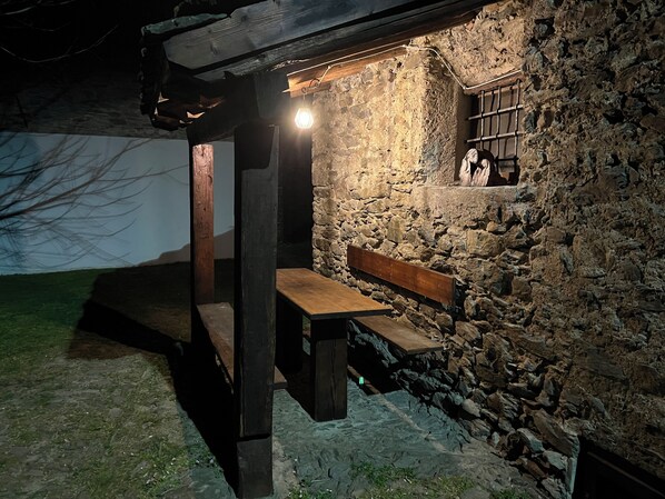 A stone wall with a wooden bench and a small window.