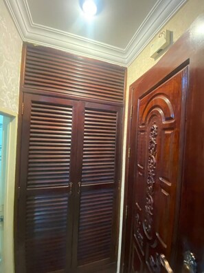 Un juego de puertas dobles con diseño tradicional, una con listones horizontales y la otra con un panel tallado.