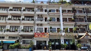 A multi-story building with balconies, a restaurant sign, and a storefront. - TWILIGHT INN (Phnom Penh)