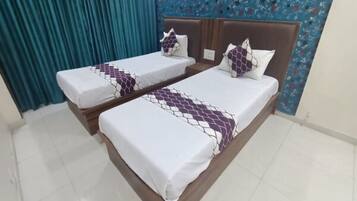 A double bed room with a patterned bedspread and matching pillows.