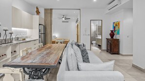 Een moderne keuken met een houten tafel en een bank in de woonkamer.