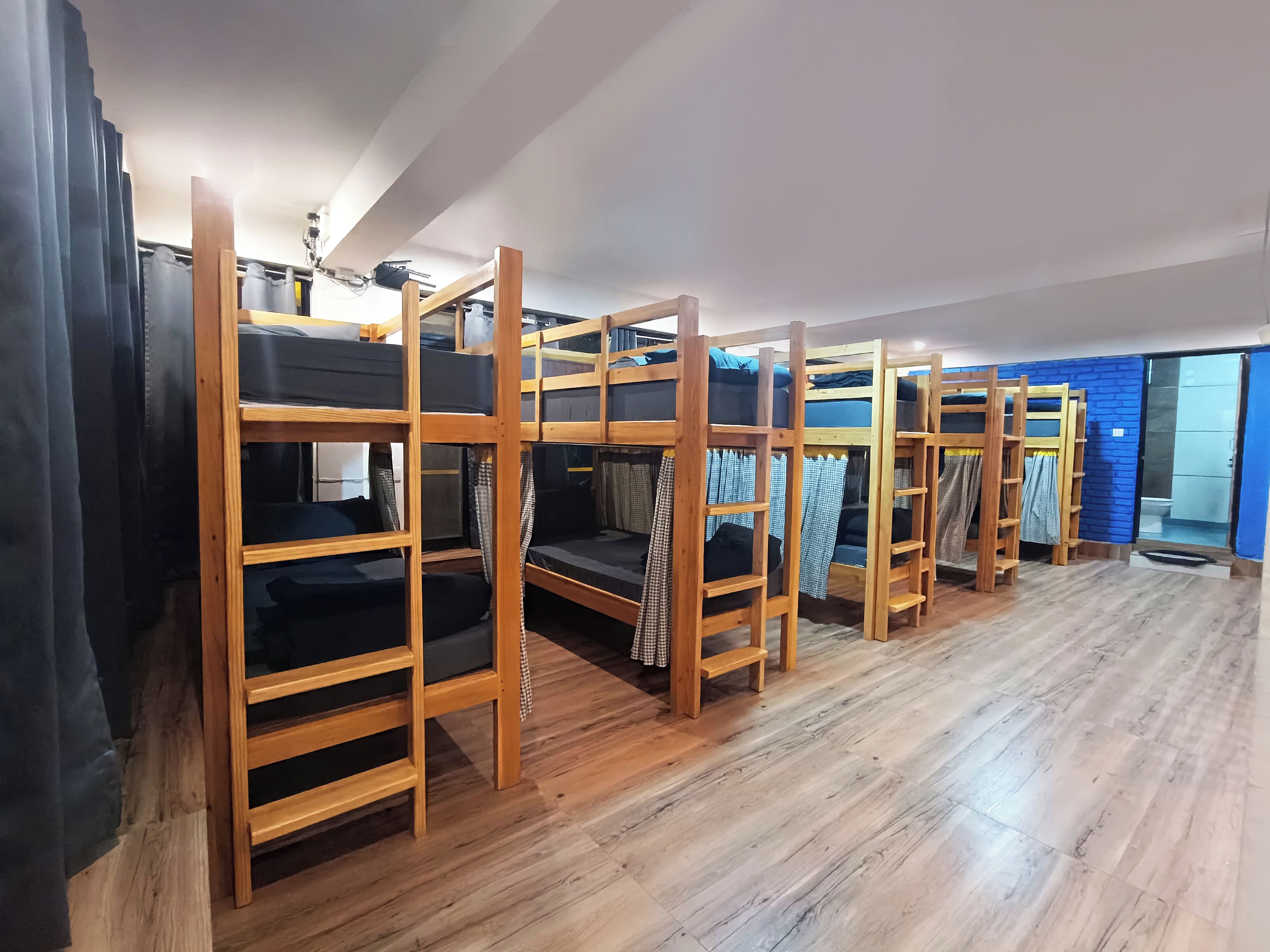A room with bunk beds and a wooden floor.