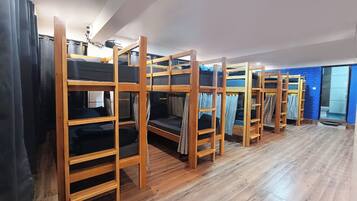 A room with bunk beds and a wooden floor.