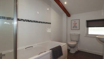 Un baño con bañera, inodoro y lavamanos.