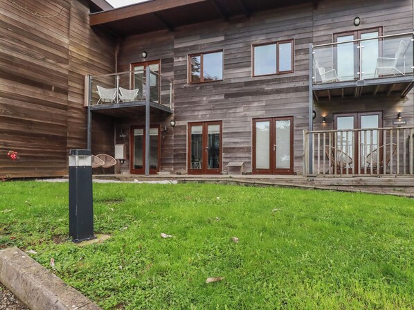 A two-story wooden building with a balcony and outdoor seating. - Trenethick (Truro)
