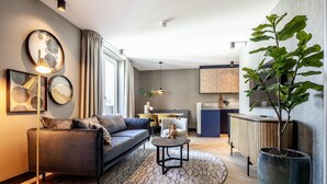 A modern living room with a sofa, a coffee table, and a large potted plant.