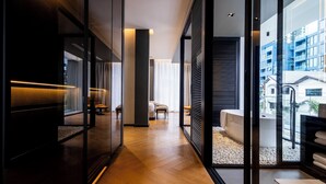 Un interior moderno con piso de madera, separaciones de vidrio y vistas de la ciudad a través de amplios ventanales.