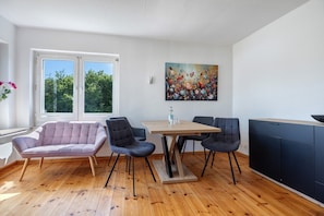 A dining area with a table, chairs, and a cabinet.