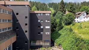 A modern building with multiple floors, large windows, and a flat roof. - Apartment Schanzenblick with Sauna & Pool in the Black Forest (Schönwald im Schwarzwald)