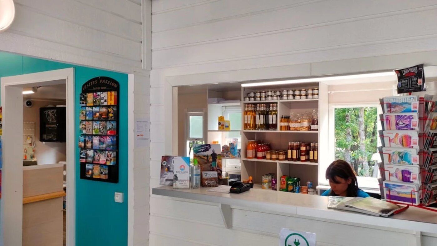 A reception area with a counter, a bulletin board, and shelves stocked with various items.