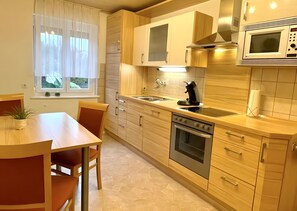 Une cuisine moderne avec des meubles en bois, un four encastré et un four à micro-ondes.