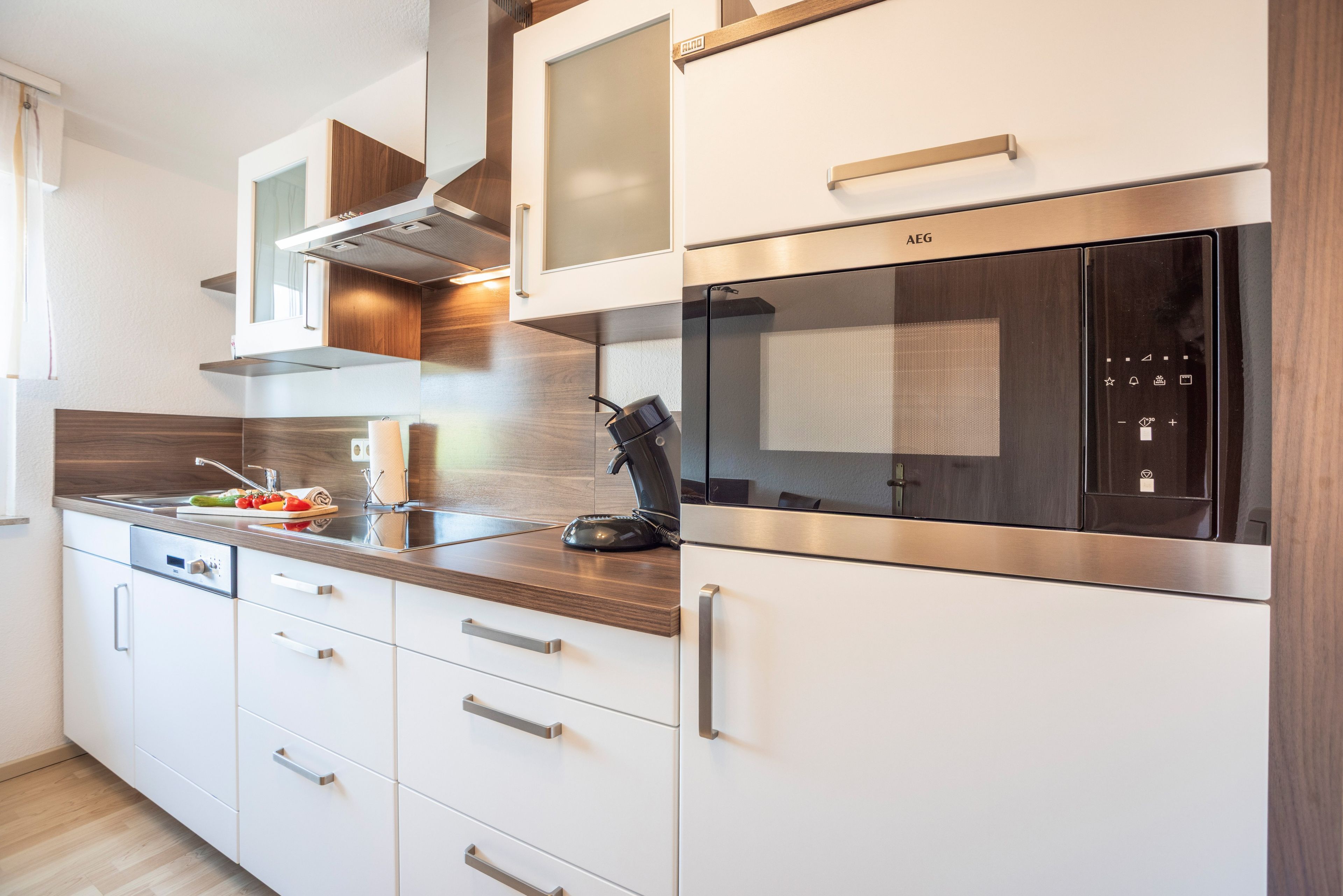 Una cocina moderna con electrodomésticos de acero inoxidable, armarios de madera y horno empotrado.