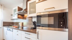 Una cocina moderna con electrodomésticos de acero inoxidable, armarios de madera y horno empotrado.