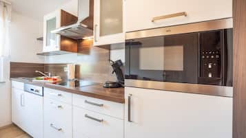 Una cocina moderna con electrodomésticos de acero inoxidable, armarios de madera y horno empotrado.
