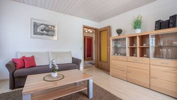 A modern living room with a sofa, coffee table, and wooden cabinets.