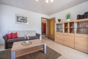 Una sala moderna con sofá, mesa de centro y armarios de madera.
