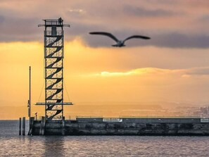 A tall, metal structure by the water during sunset. - Apartment 'Zeppelin N T' with Terrace and Wi-Fi (Friedrichshafen)