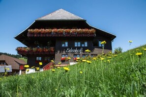 Un edificio a due piani con balconi decorati da fiori, con la scritta 'Elenhof'.
