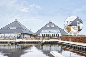 A residential area with two houses, a small dock, and a body of water. - Apartment in Friesland with Waterfront Views (Offingawier)