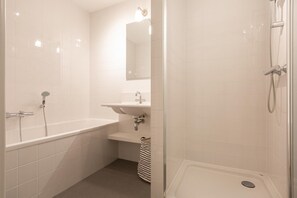 A bathroom with a bathtub, sink, and shower. - Apartment in Den Haag with Balcony (Den Haag)