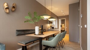 A modern dining area with a wooden table, bench, and two chairs. - 3-bedroom duplex apartment in Den Haag (Den Haag)