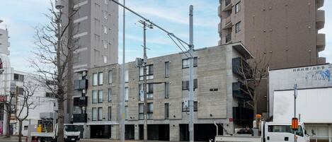 A multi-story building with a modern architectural design, featuring a mix of balconies and large windows.