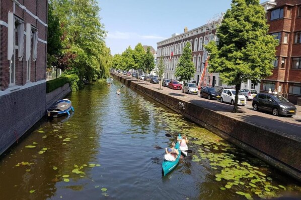 Un canal con un bote y una estrecha vía fluvial bordeada por edificios.