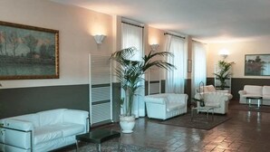 A spacious living room with white sofas, a coffee table, and potted plants. - Holiday Home near Assisi with Pool (Assisi)