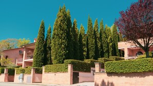 A residential building with a brick facade, a balcony, and a well-maintained hedge. - Holiday Home near Assisi with Pool (Assisi)