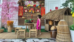 A traditional interior with a child, a decorative wall, and a thatched-roof structure. - Blue Ocean Hotel Phan Thiet - BAY LUXURY (Phu Thuy)